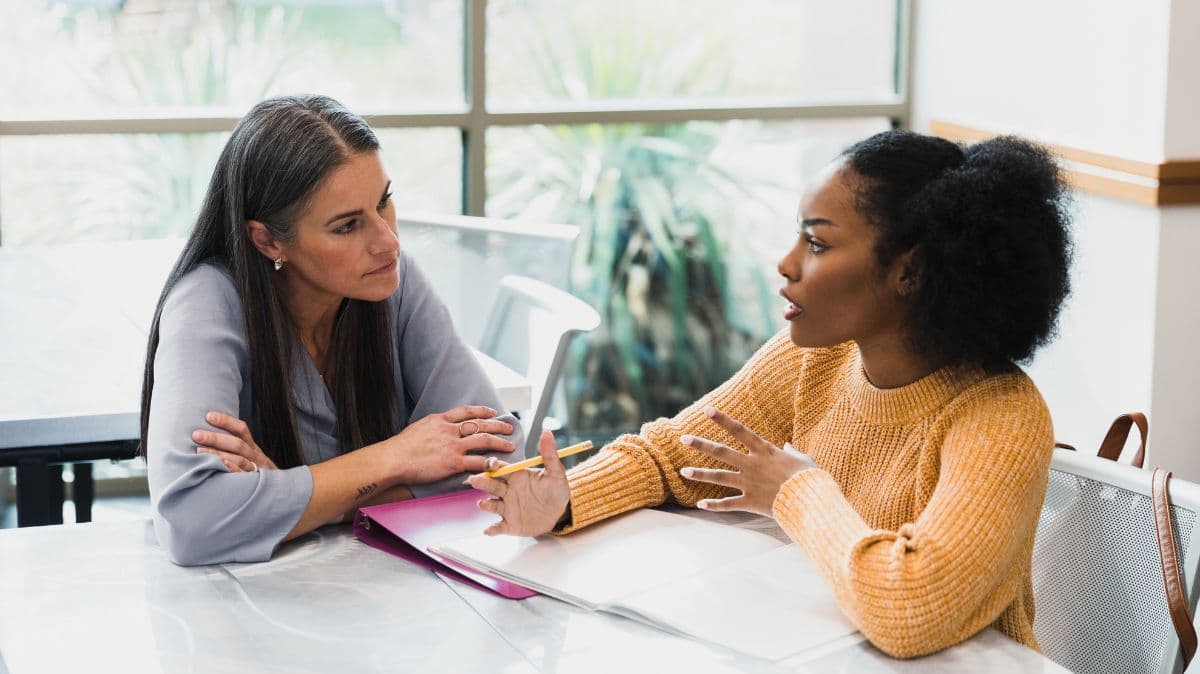 Dos profesionales conversan durante una sesión de coaching ejecutivo en un entorno de trabajo.