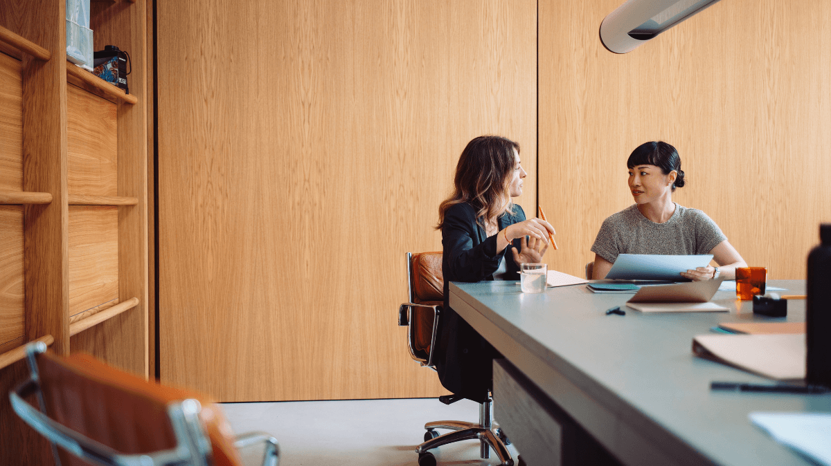 Dos profesionales conversan en una sesión de coaching individual, representando desarrollo de liderazgo, comunicación y crecimiento profesional.