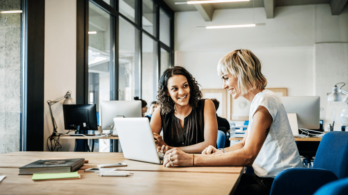 Profesionales conversan en un entorno de trabajo, representando liderazgo saludable, bienestar y seguridad psicológica en los equipos.