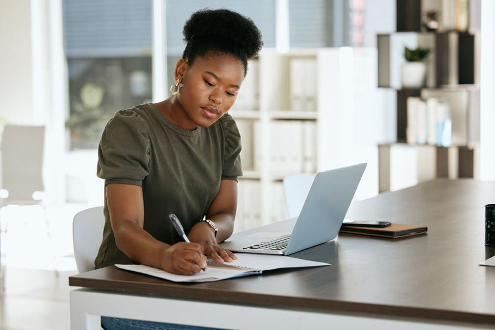 A woman sits at his computer reviewing information related to retiree annuity buyout planning for plan sponsors, reflecting a thoughtful and strategic decision-making process.